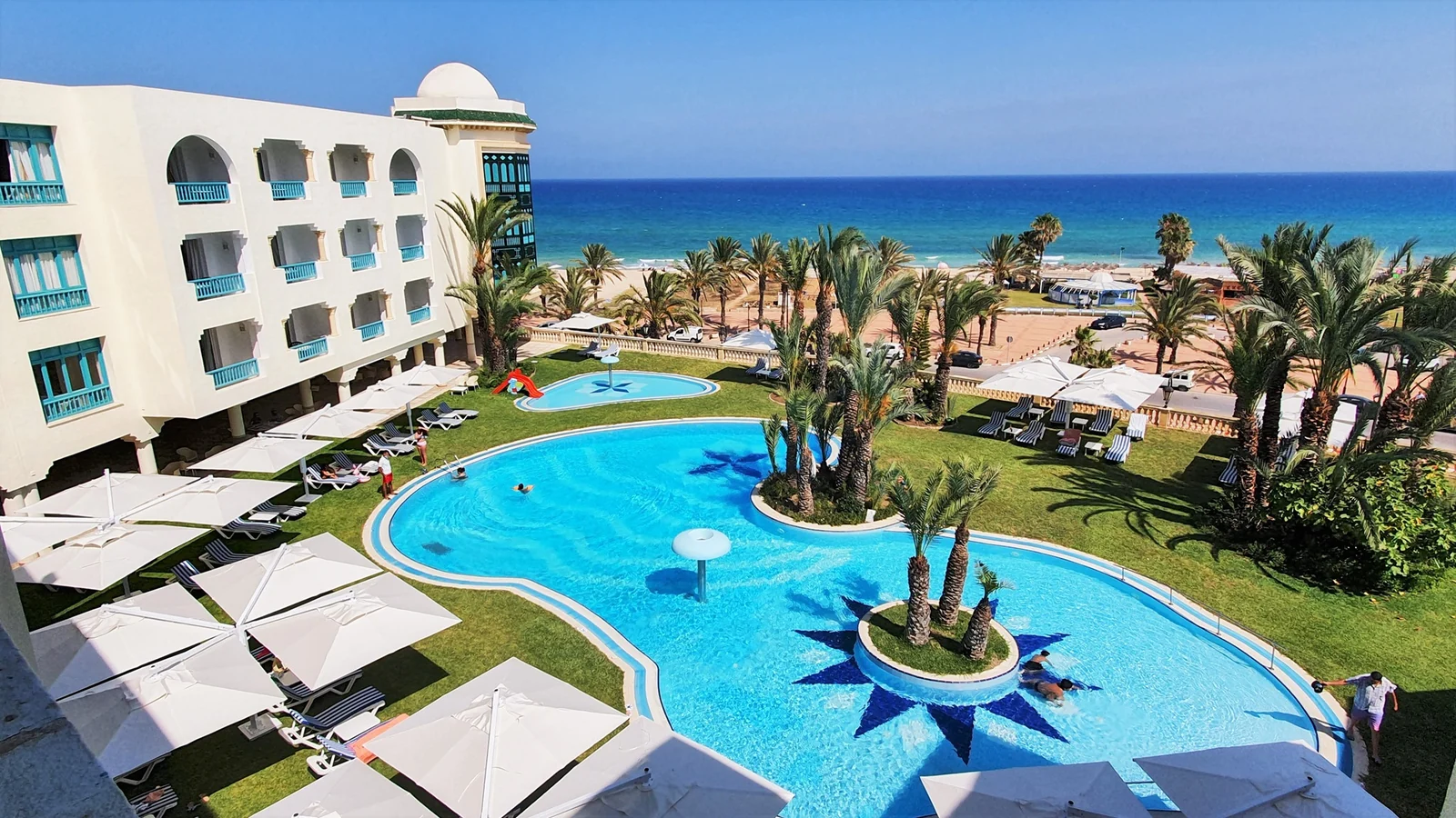 Turquoise outdoor pool, palms and the Mediterranean at Méhari Hammamet